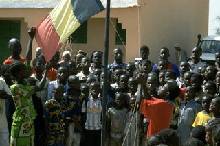 Schulkinder singen die Nationalhymne und hissen die Nationalflagge