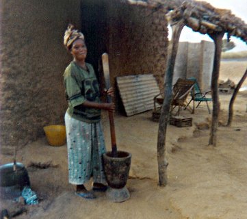 Frau beim Stampfen von Getreide